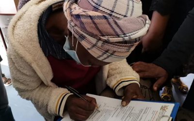 A beneficiary signing off a Happy letter after receiving a brand-new house in Tolofiyeni village.